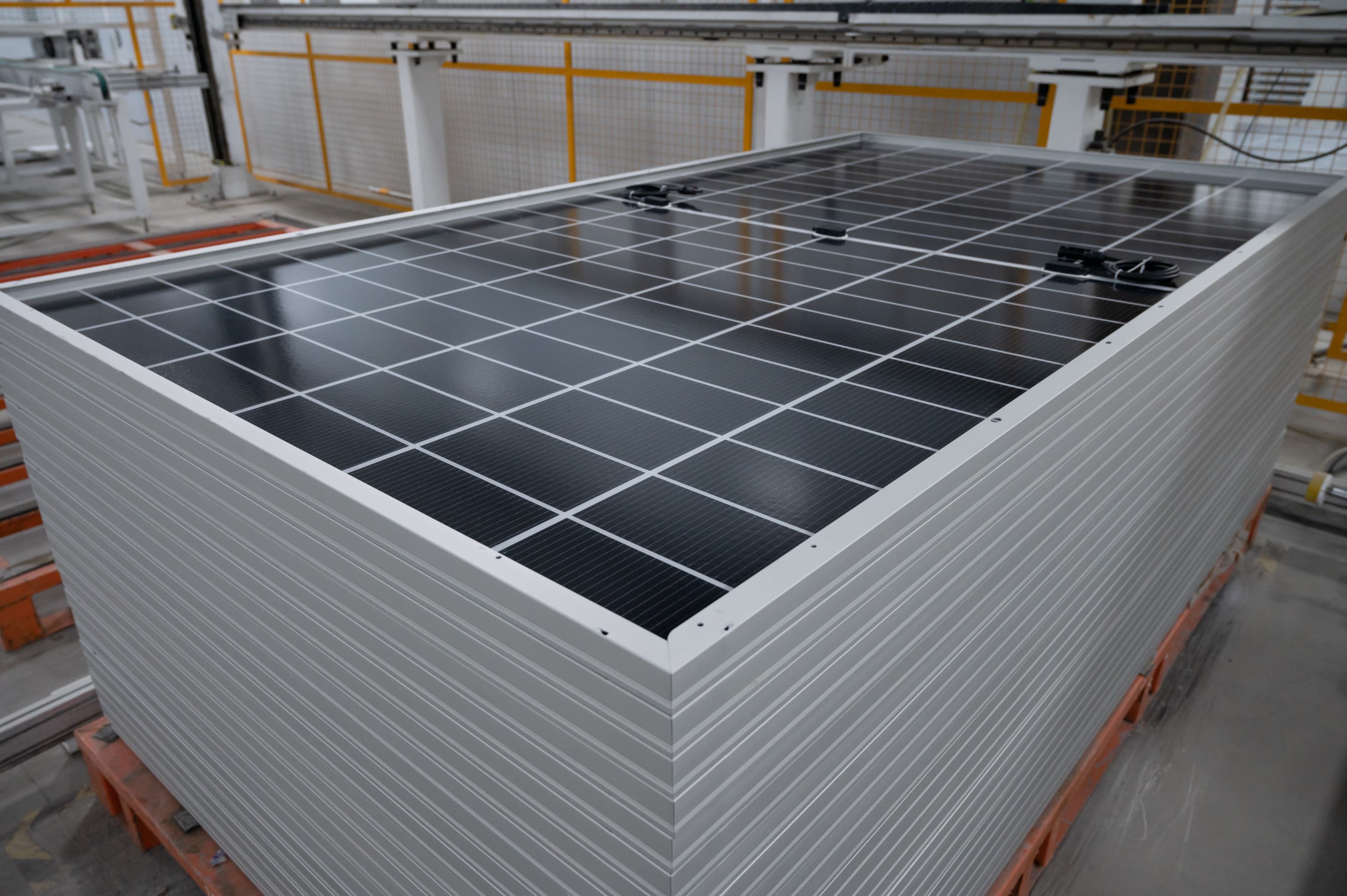 Finished solar modules stacked on a pallet in a manufacturing facility